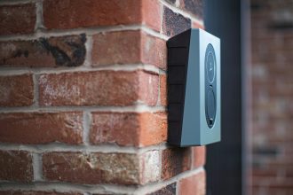 Wall-mounted electricity meter on a brick exterior wall of a UK home